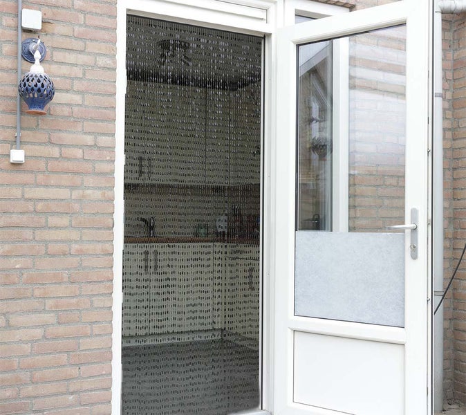 Geöffnete Terrassentür mit Insektenschutzvorhang