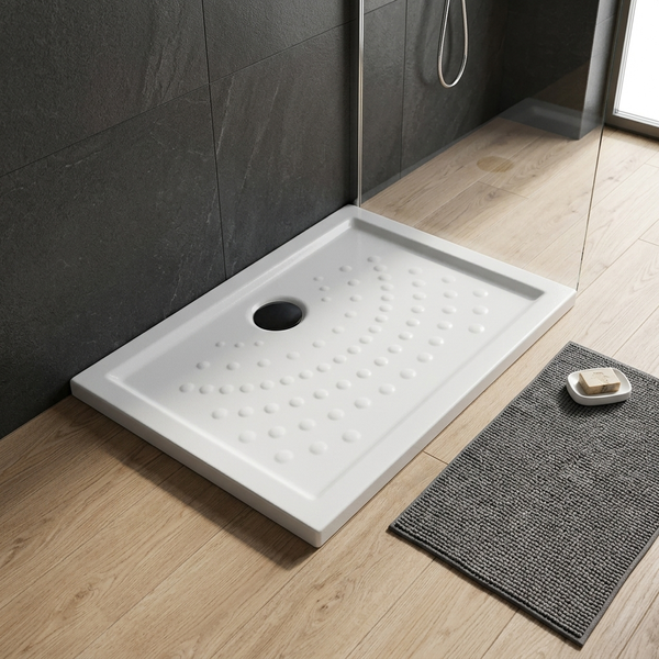 Weiße rechteckige Duschwanne mit Noppenstruktur und schwarzem Ablauf in einem modernen Badezimmer mit dunklen Wandfliesen und Holzboden.