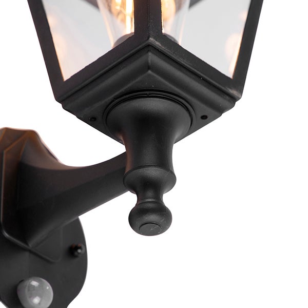 Schwarze Außenwandleuchte im Laternen-Stil mit Bewegungsmelder und klarem Glas.