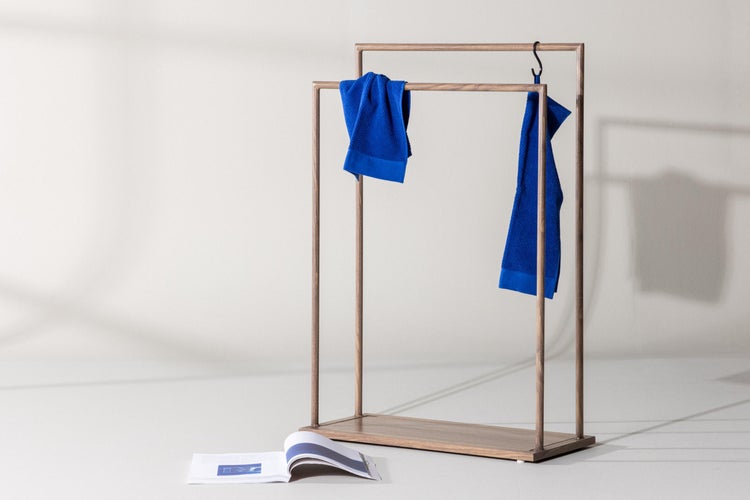 Freistehender Handtuchhalter aus Holz mit zwei parallelen Stangen auf verschiedenen Höhen und einer rechteckigen Bodenplatte.