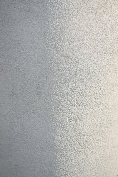Nahaufnahme der koernigen Oberflaechenstruktur von Mineralputz