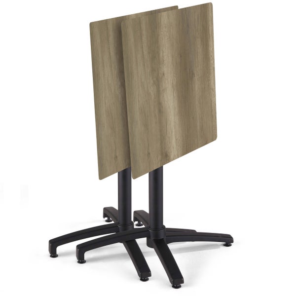 Zwei zusammengeklappte Bistrotische mit quadratischen Tischplatten in Holzoptik und schwarzen Metallgestellen.