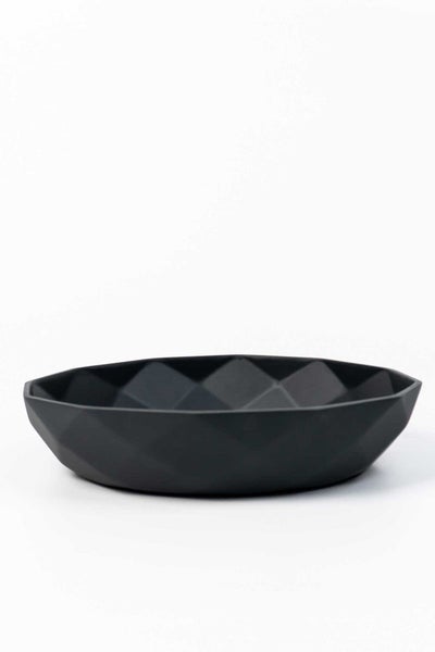 Flache, runde Schale aus schwarzem Kunststoff mit geometrischem Diamantmuster.