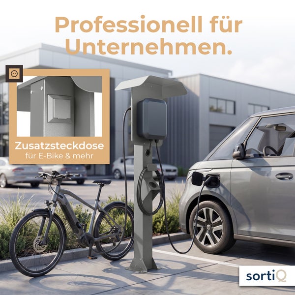 Ladestation für Elektrofahrzeuge mit integrierter Zusatzsteckdose für E-Bikes, montiert auf einer Stele im Außenbereich eines Unternehmens.