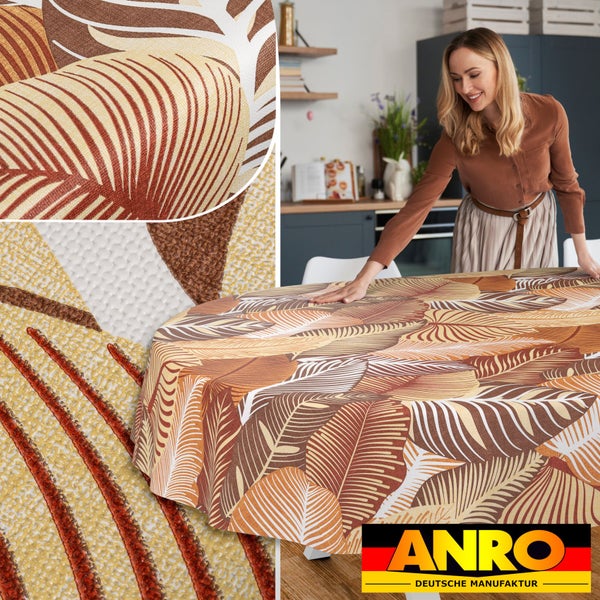 Runde, abwischbare Tischdecke mit Blattmuster in Erdtönen auf einem Tisch. Eine Frau breitet die Decke in einer Küche aus. ANRO Logo.