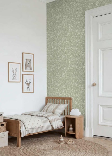 Helles Kinderzimmer mit floraler Tapete, einem Holzbett mit gestreifter Bettwäsche und gerahmten Tierbildern an der Wand.