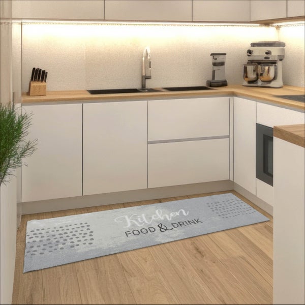 Hellgrauer Küchenläufer mit Schriftzug Kitchen Food und Drink auf einem hellen Holzboden in einer modernen weißen Küche.