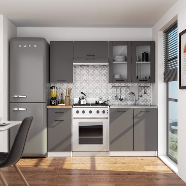 Helle Küche mit grauen Schränken, silberfarbenem Kühlschrank der Marke Smeg und weißen Elektrogeräten.