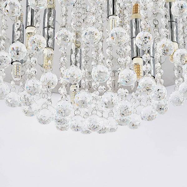 Detailansicht einer Kristall-Deckenleuchte mit facettierten Glaskugeln an Metallketten und integrierten Leuchtmitteln.