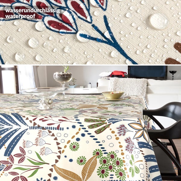 Wasserundurchlässige Tischdecke mit buntem Blumenmuster in einem hellen Wohnzimmer mit Wassertropfen auf der Oberfläche.