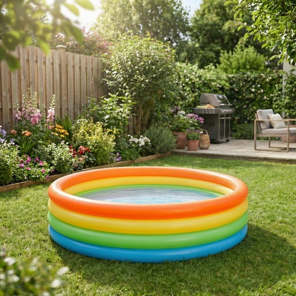 Buntes aufblasbares Planschbecken mit drei Ringen steht auf einer Gartenwiese im Sommer.
