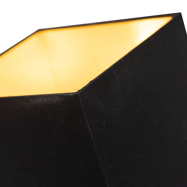 Detailansicht einer schwarzen Lampe mit goldenem Innenraum