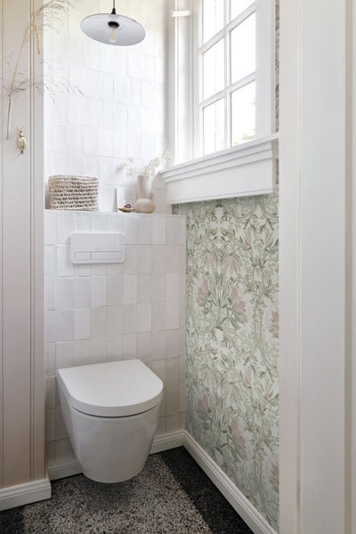 Modernes Badezimmer mit Toilette, Fliesen und floraler Tapete