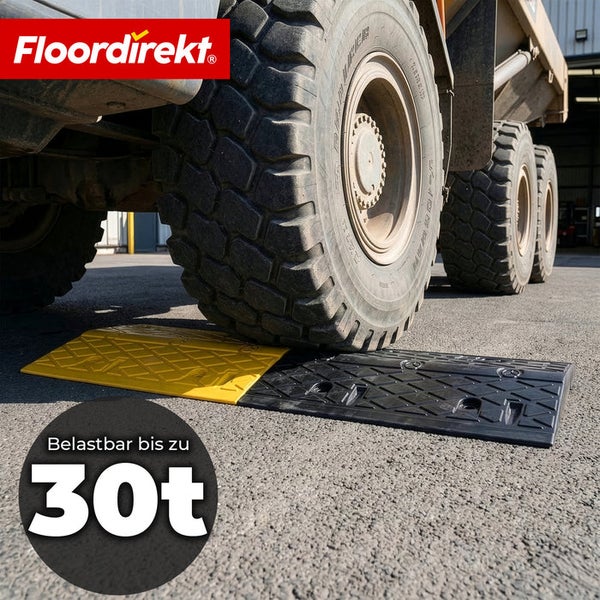 Floordirekt Logo. Ein großer Lastkraftwagenreifen überfährt eine Bordsteinrampe aus Gummi. Belastbarkeit bis zu 30 Tonnen.