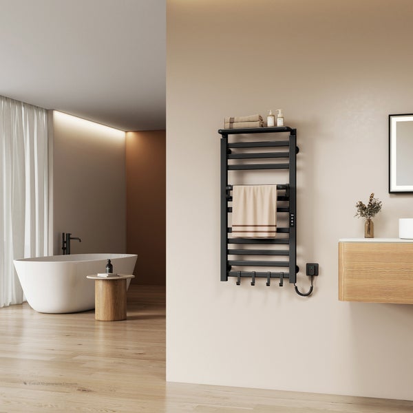 Modernes, helles Badezimmer mit einem schwarzen elektrischen Handtuchheizkörper an einer hellen Wand, einer freistehenden Badewanne und Holzdekor.