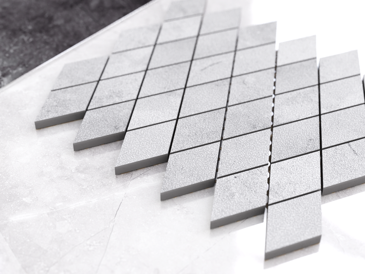 Graue Mosaikfliese in Rautenform aus Feinsteinzeug.