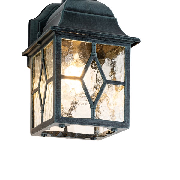 Rustikale Außenwandleuchte aus dunklem, wetterbeständigem Metall mit strukturierten Glasscheiben und dekorativem Rautengitter.