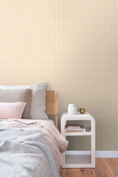 Schlafzimmer mit Bett und Nachttisch vor einer Wand mit quadratischem Muster