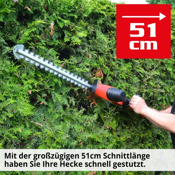 Eine Heckenschere mit einer Schnittlänge von 51 Zentimetern im Einsatz vor einer Hecke.