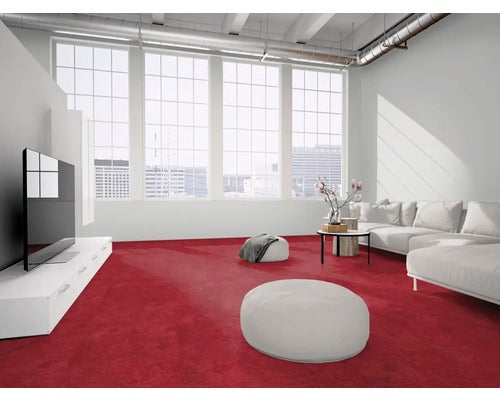 Modernes Wohnzimmer im Industrie-Stil mit rotem Teppichboden, weißem Sofa, Sitzpuffs und großen Fensterfronten.