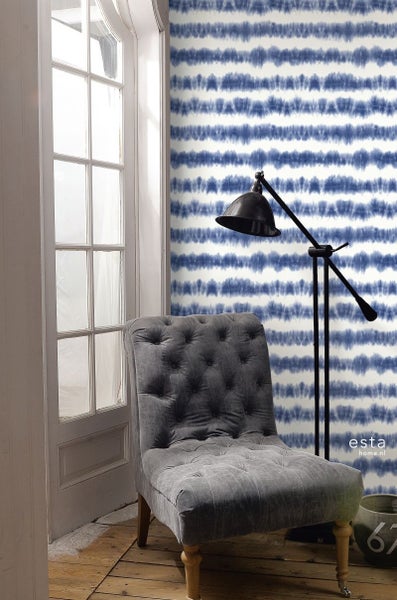 Raumansicht mit Sessel, Stehlampe und Tapete mit Streifenmuster