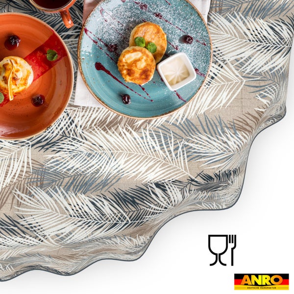 Abwaschbares Wachstischtuch mit Palmenblatt-Muster, gedeckter Tisch mit Frühstück, lebensmittelecht, ANRO Deutsche Manufaktur Logo.