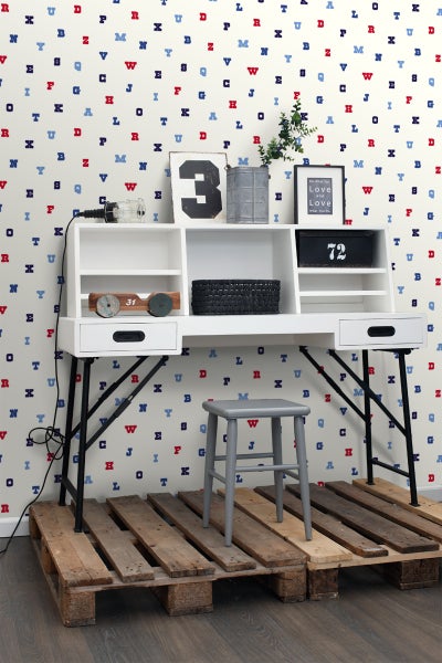 Schreibtisch mit Ablagefächern, Hocker und Dekoration auf Holzpalette