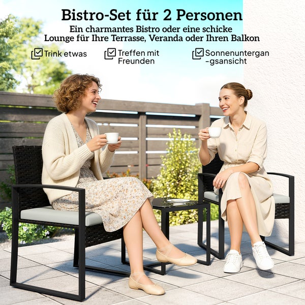 Bistro-Set für 2 Personen auf einer hellen Terrasse mit zwei schwarzen Rattansesseln, hellen Polstern und einem kleinen Beistelltisch.