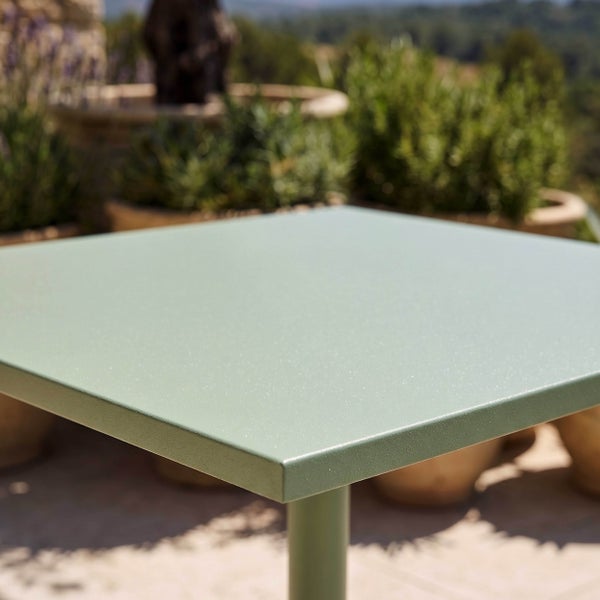 Quadratische grüne Tischplatte eines Gartentischs aus Metall für den Außenbereich.