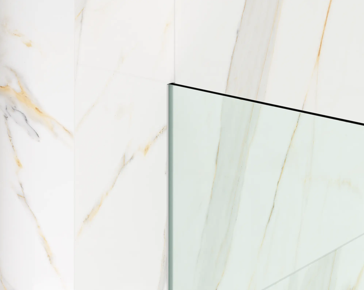 Glasduschwand montiert an einer Wand mit weißer Marmoroptik.