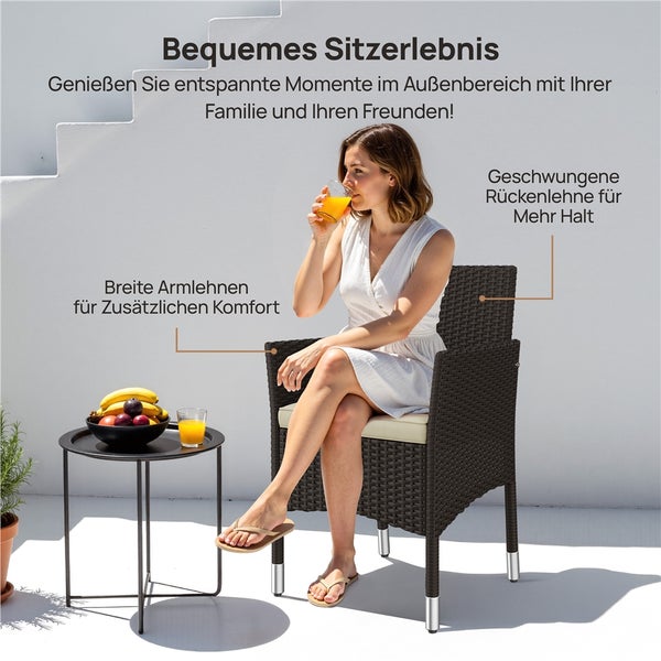 Frau sitzt in einem Gartenstuhl aus Polyrattan mit breiten Armlehnen und geschwungener Rückenlehne neben einem runden Beistelltisch im Außenbereich.