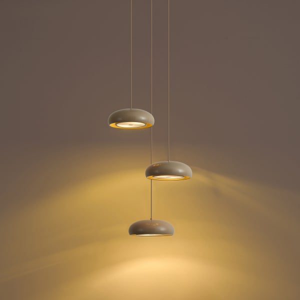 Moderne Pendelleuchte mit drei runden Schirmen in verschiedenen Höhen hängend für eine gleichmäßige Lichtverteilung.