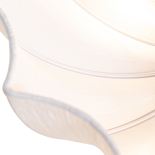 Nahaufnahme eines gewellten Lampenschirms aus Stoff mit feiner Textur und sichtbaren Streben.