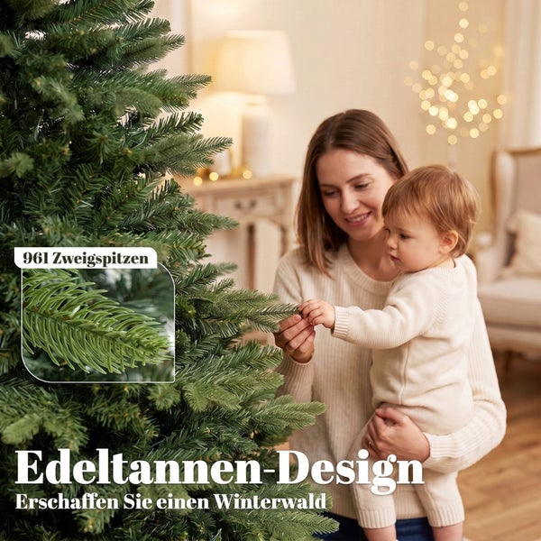 Eine Frau hält ein Kind, das die Zweige eines künstlichen Weihnachtsbaums im Edeltannen Design mit 961 Zweigspitzen berührt.