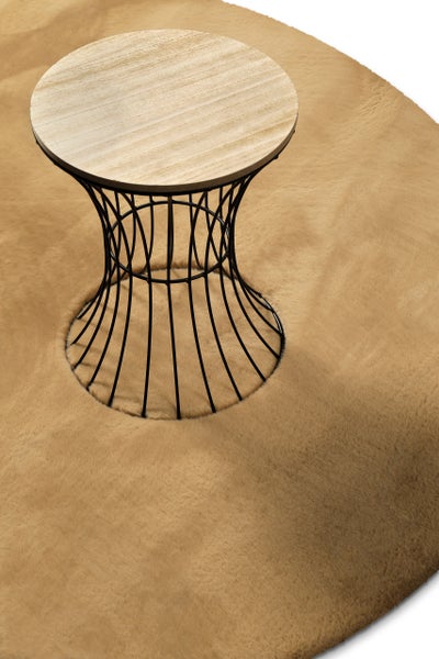 Runder Kunstfellteppich mit weichem Flor unter einem runden Beistelltisch mit Holzplatte und Metallgestell.