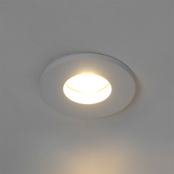 Runder LED Einbaustrahler in Weiß, eingeschaltet mit warmweißem Licht, Deckenmontage.