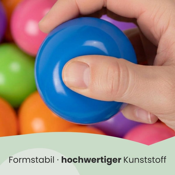 Hand drückt einen Bällebadball aus hochwertigem Kunststoff zur Demonstration der Formstabilität.