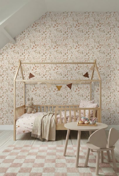 Helles Kinderzimmer mit Tapete im Pferdedesign, Hausbett aus Holz, rundem Spieltisch und einem karierten Teppich.