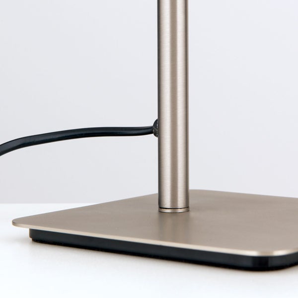 Detailansicht einer Tischleuchte mit Metallfuß und Stromkabel