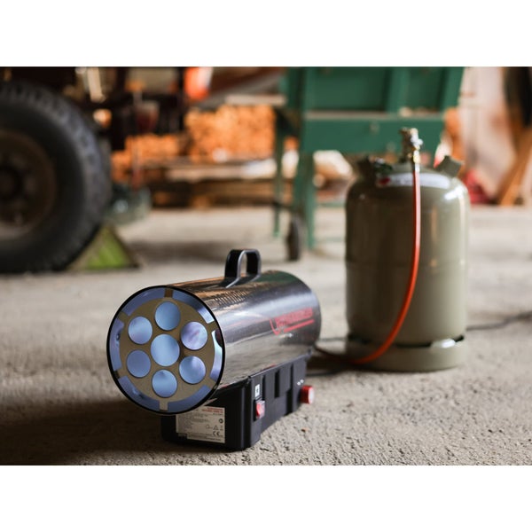 Gasheizgebläse angeschlossen an eine Propangasflasche mit Druckregler und orangefarbenem Schlauch.