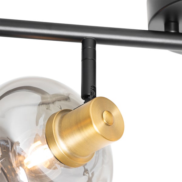 Detailansicht einer Deckenleuchte mit Glaskugelschirm und Metallelementen