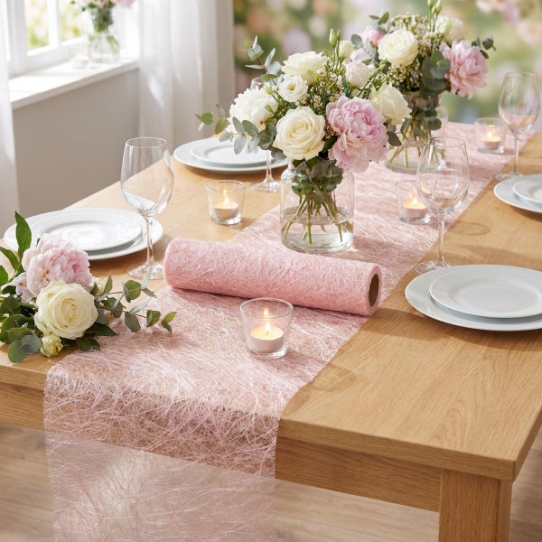 Festlich gedeckter Holztisch mit rosafarbenem Sisal Tischband und Blumenarrangements sowie Gläsern und Kerzen für eine elegante Tischdekoration