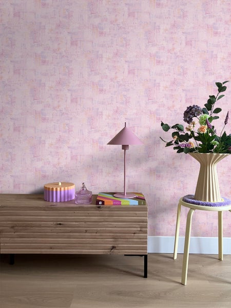 Dekoratives Zimmer mit gemusterter Tapete, Kommode, Tischlampe und Blumenstrauß