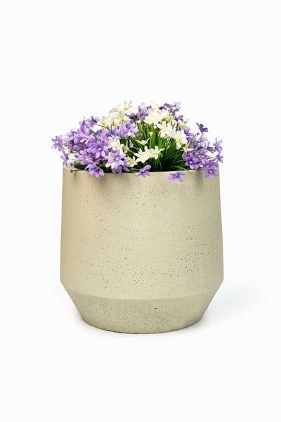 Konischer Blumentopf aus Beton mit künstlichen lila und weißen Blumen.