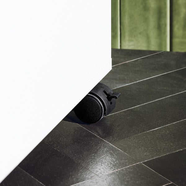 Detailaufnahme einer schwarzen Möbelrolle unter einem Schrank