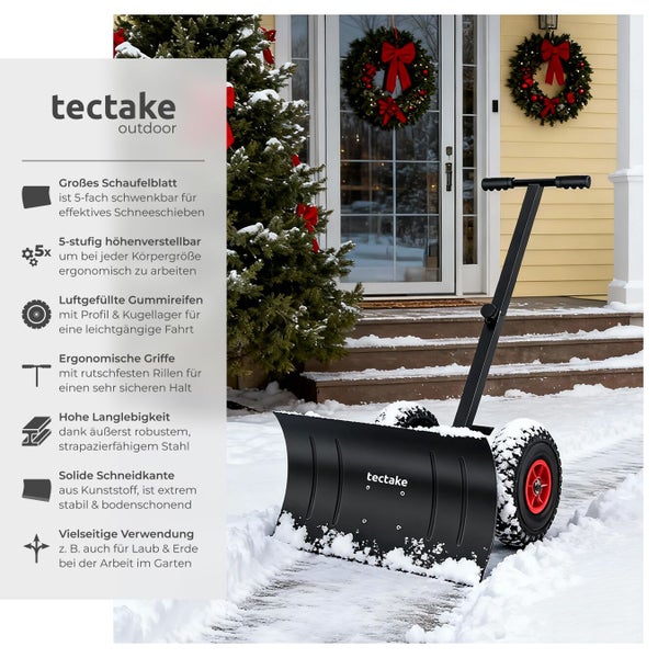 Schneeschieber mit Rädern vor einem Haus mit Weihnachtsschmuck.