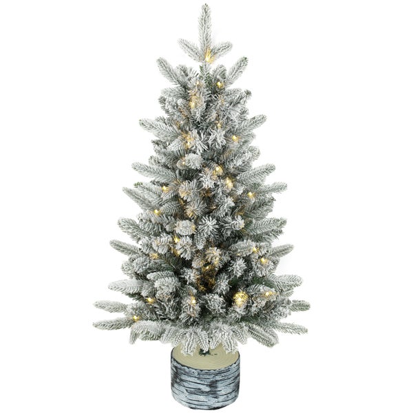 Künstlicher Weihnachtsbaum mit LED Beleuchtung und beschneiten Zweigen in einem dekorativen Baumständer in Holzoptik
