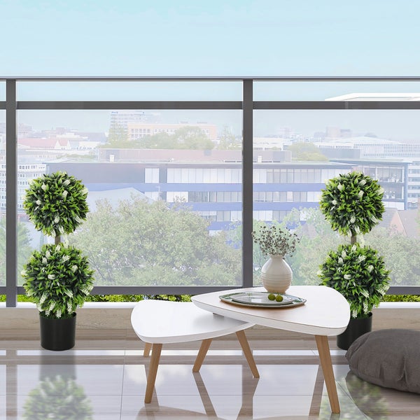 Wohnzimmer mit dekorativen Kunstpflanzen und modernem Tisch