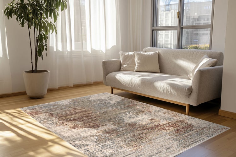 Wohnzimmer mit modernem Sofa und strukturiertem Teppich auf Parkettboden neben einer Topfpflanze bei hellem Tageslicht.