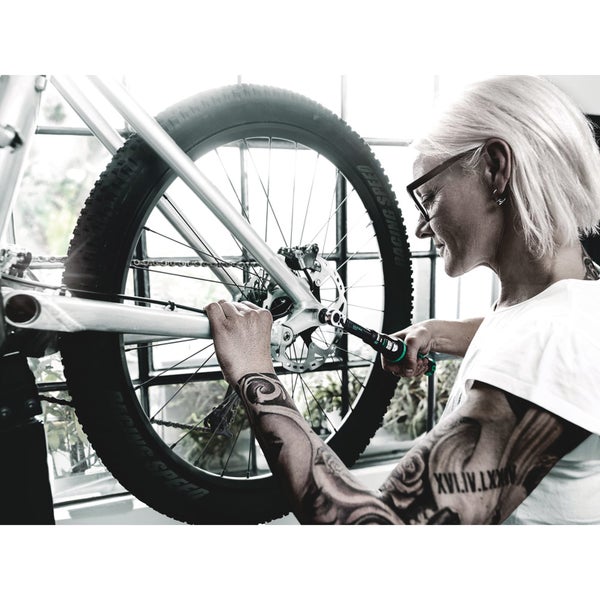 Frau repariert Fahrrad mit Drehmomentschlüssel